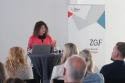 Dr. Maya Götz an einem Stehtisch, im Hintergrund ein Banner der ZGF